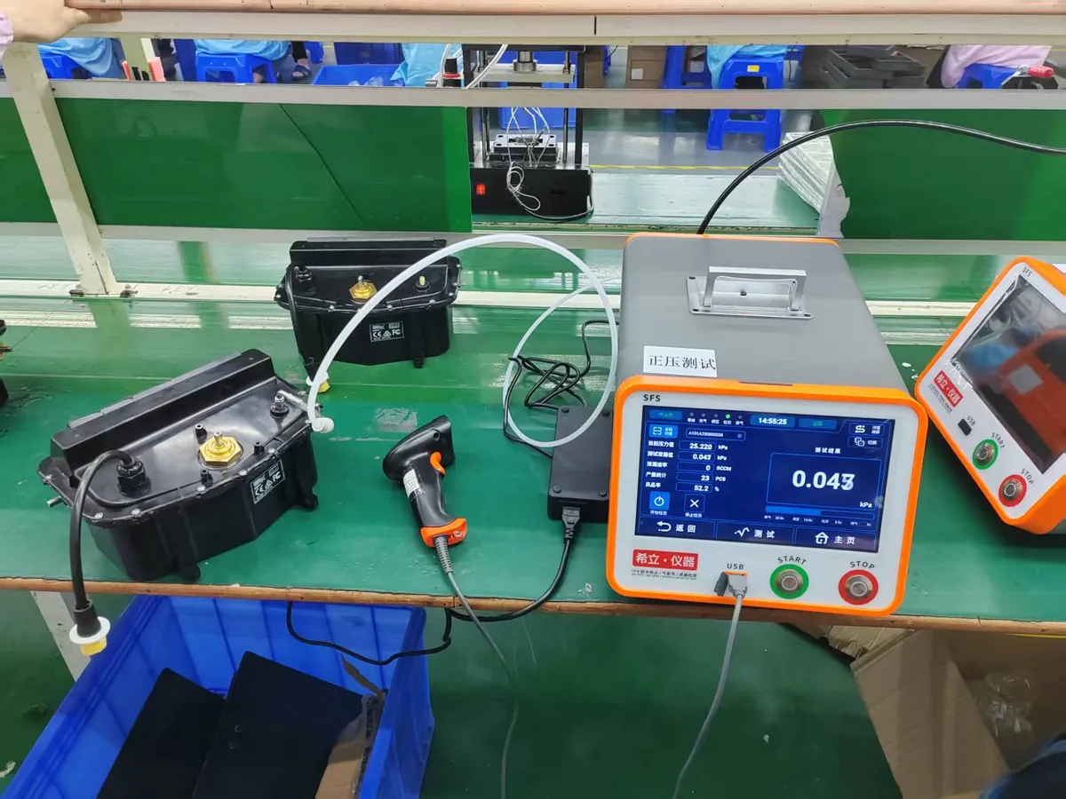 Leak test on a pool cleaning robot housing at a factory test bench, with a digital gauge reading 0.043 kPa.